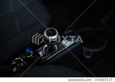 Close-up of a modern car central console with rotary gear selector Close-up of a modern car central console with rotary gear selector 143007117
