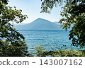 初夏時節，透過樹木眺望北海道支笏湖和福布希山，碧波蕩漾。 143007162