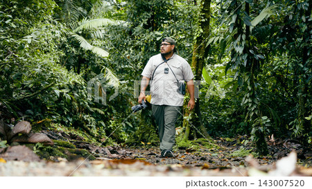 Man exploring rainforest path, enjoying nature in Arenal Volcano National Park Man exploring rainforest path, enjoying nature in Arenal Volcano National Park 143007520