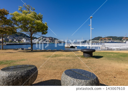 A port town landscape like an urban oasis, with a clear blue sky and calm waters. A port town landscape like an urban oasis, with a clear blue sky and calm waters. 143007610