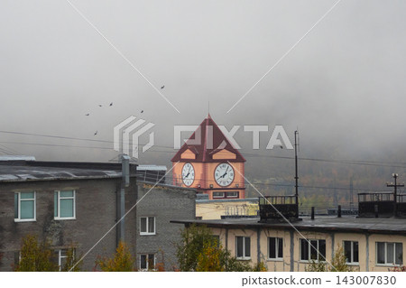 Industrial northern town architecture with central clock tower in fog Industrial northern town architecture with central clock tower in fog 143007830