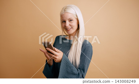 Blonde woman smiling using smartphone for communication 143008249