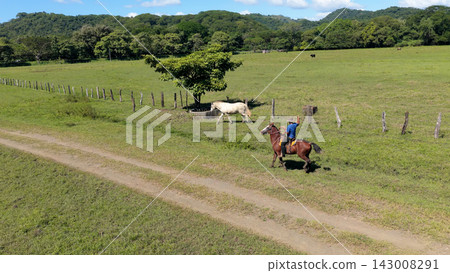 Cowboy riding ranch horse on a rural pasture road Cowboy riding ranch horse on a rural pasture road 143008291