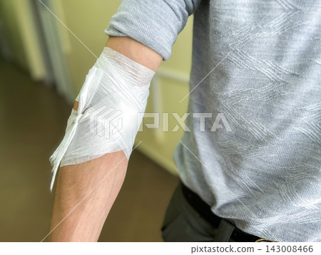 Bandaged male arm after blood donation at modern donation clinic. Giving blood from vein. Charity, healthcare and helping people in need concept Bandaged male arm after blood donation at modern donation clinic. Giving blood from vein. Charity, healthcare and helping people in need concept 143008466