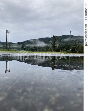 Misty mountains and cloudy sky reflected in puddles after the rain. Misty mountains and cloudy sky reflected in puddles after the rain. 143008596