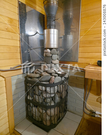 Sauna stove with hot stones and metal chimney pipes Sauna stove with hot stones and metal chimney pipes 143008876