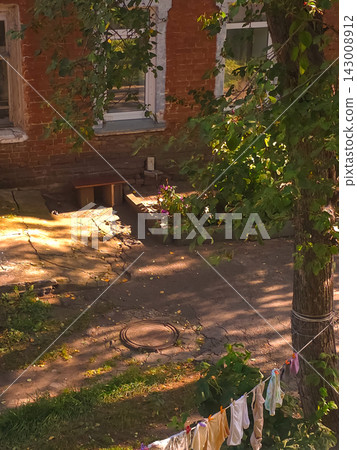 Courtyard with laundry line and red brick house windows Courtyard with laundry line and red brick house windows 143008912