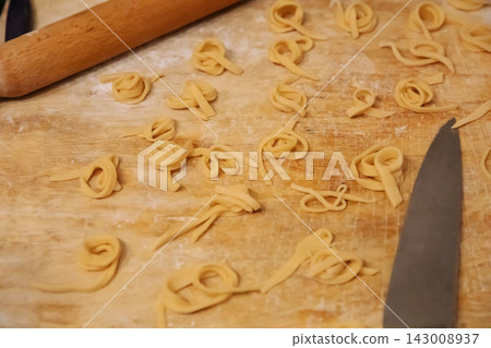 Top view of homemade noodles and knife on wooden board Top view of homemade noodles and knife on wooden board 143008937