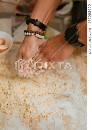 Top view of hands kneading pasta dough with flour Top view of hands kneading pasta dough with flour 143008960
