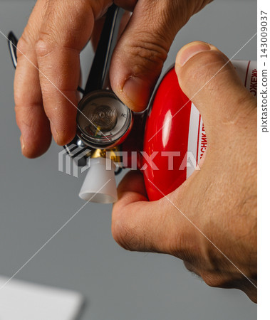 Fire extinguisher inspection in progress with safety measures in place Fire extinguisher inspection in progress with safety measures in place 143009037