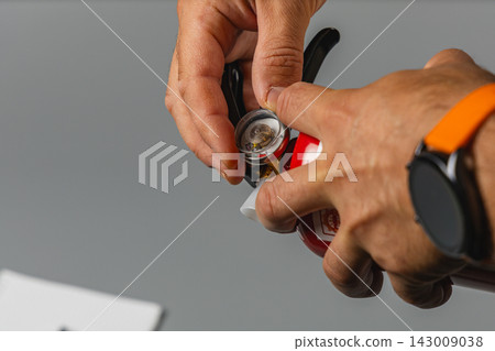 Inspection of a fire extinguisher in a safety equipment maintenance setting Inspection of a fire extinguisher in a safety equipment maintenance setting 143009038