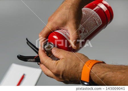 Checking the pressure gauge on a fire extinguisher for safety Checking the pressure gauge on a fire extinguisher for safety 143009041