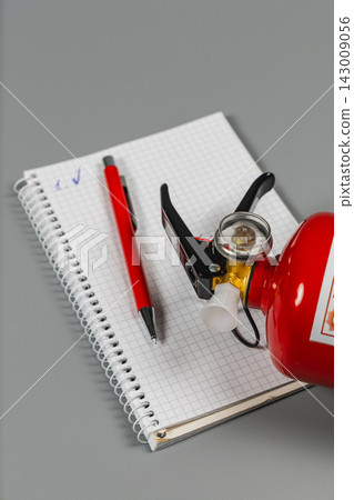 Use of fire extinguisher with notepad and pen for safety checks Use of fire extinguisher with notepad and pen for safety checks 143009056