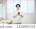 一位身著休閒職業裝的年輕男子手持智慧型手機 143009154