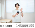 一位身著休閒職業裝的年輕男子手持智慧型手機 143009155