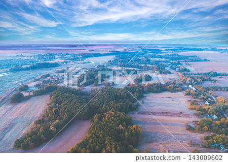 Summer rural landscape. Aerial view. View of plowed and green fields and village in the evening Summer rural landscape. Aerial view. View of plowed and green fields and village in the evening 143009602