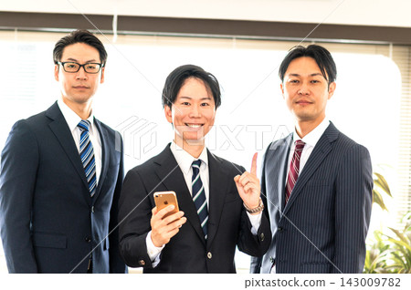 三名身穿西裝的男子和一名身穿西裝、手持智慧型手機的男子正在指向。 三名身穿西裝的男子和一名身穿西裝、手持智慧型手機的男子正在指向。 143009782