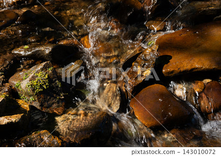 Water flowing over rocks in stream Water flowing over rocks in stream 143010072