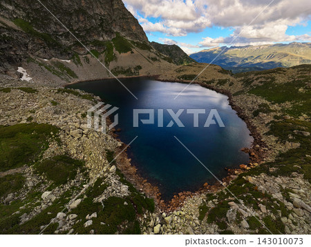 Aerial View of Alpine Lake Surrounded by Rocky Mountains Aerial View of Alpine Lake Surrounded by Rocky Mountains 143010073