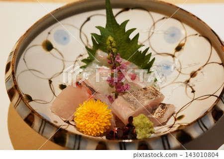 White fish sashimi served on a decorated round plate 143010804