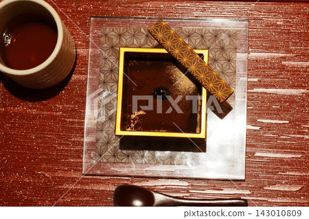 Japanese sweets generously covered in kinako (roasted soybean flour) and a golden lid Japanese sweets generously covered in kinako (roasted soybean flour) and a golden lid 143010809