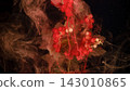 Red currant clusters submerged in swirling red ink with moody black background 143010865