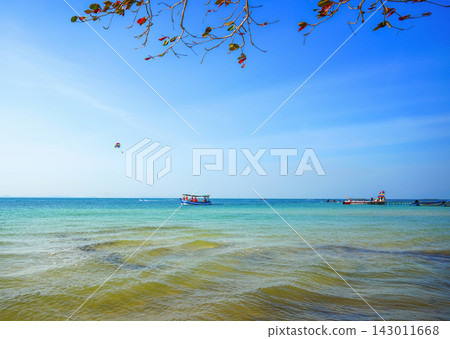 Fast motorboat carries tourists across ocean. Boat moves sea on sunny day at coastline in tropical  143011668