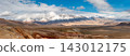 Snowcapped Mountains in Vast Desert Landscape. Panorama of Golden Autumn Mountain Altai. Beautiful view on fall valley foreground and amazing sky above the snow-capped mountain peaks background 143012175
