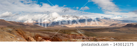 Snowcapped Mountains in Vast Desert Landscape. Panorama of Golden Autumn Mountain Altai. Beautiful view on fall valley foreground and amazing sky above the snow-capped mountain peaks background 143012175