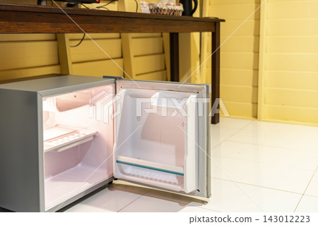 Mini refrigerator, wooden cabinet, and open wardrobe create a simple room layout focused on storage, practical furniture, and everyday accommodation use. Mini refrigerator, wooden cabinet, and open wardrobe create a simple room layout focused on storage, practical furniture, and everyday accommodation use. 143012223