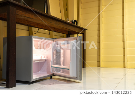 Mini refrigerator, wooden cabinet, and open wardrobe create a simple room layout focused on storage, practical furniture, and everyday accommodation use. Mini refrigerator, wooden cabinet, and open wardrobe create a simple room layout focused on storage, practical furniture, and everyday accommodation use. 143012225
