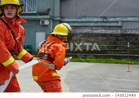 Firefighters Working Together During Outdoor Hose Drill Firefighter Training Exercise Firefighters Working Together During Outdoor Hose Drill Firefighter Training Exercise 143012449