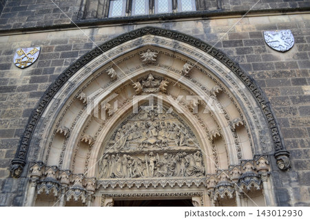 Gothic carved church portal arch with sculpted tympanum and decorative reliefs for historic architecture background and restoration. Basilica of St Peter and St Paul, Prague. Gothic carved church portal arch with sculpted tympanum and decorative reliefs for historic architecture background and restoration. Basilica of St Peter and St Paul, Prague. 143012930