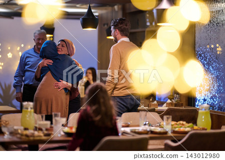 Family Reunion Dinner: Relatives Embrace at a Warm Restaurant Gathering During Holiday Celebration 143012980