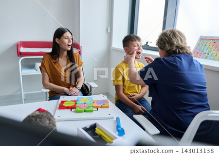 Child receives dental checkup while mother observes in a bright, modern clinic 143013138