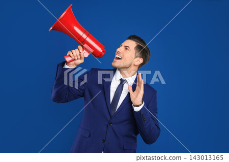Handsome man with megaphone on blue background Handsome man with megaphone on blue background 143013165