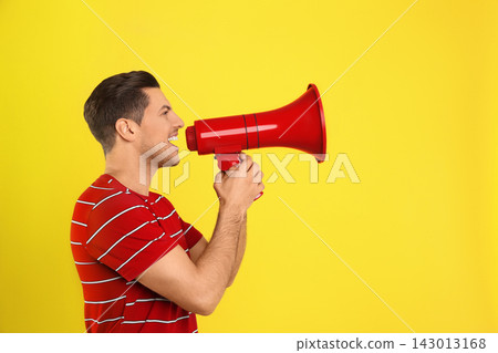 Handsome man with megaphone on yellow background. Space for text Handsome man with megaphone on yellow background. Space for text 143013168
