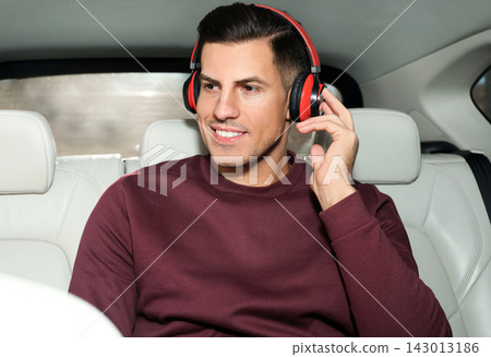 Handsome man listening to audiobook in car Handsome man listening to audiobook in car 143013186