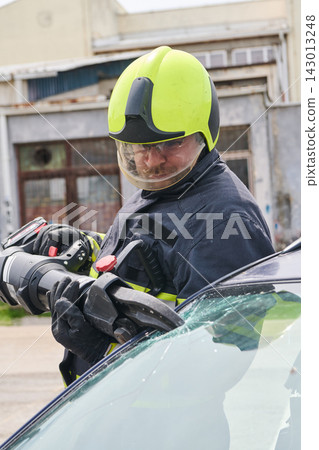 Firefighter Using Hydraulic Rescue Cutter To Extricate Victim From Crashed Car During Emergency Rescue Firefighter Using Hydraulic Rescue Cutter To Extricate Victim From Crashed Car During Emergency Rescue 143013248