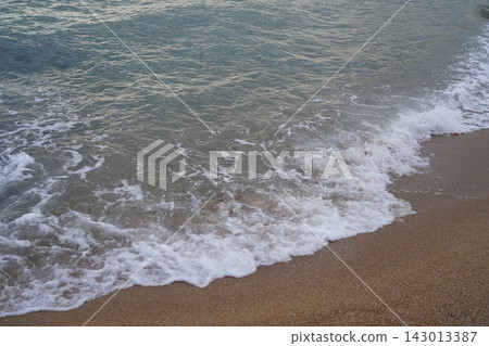 Ocean Waves Gently Lapping on Sandy Beach Shoreline Ocean Waves Gently Lapping on Sandy Beach Shoreline 143013387