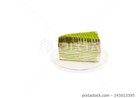 Slice of layered matcha green tea crepe cake with drizzled green tea sauce isolated on white background. Slice of layered matcha green tea crepe cake with drizzled green tea sauce isolated on white background. 143013395