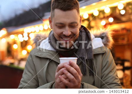 Happy man with mulled wine at winter fair Happy man with mulled wine at winter fair 143013412