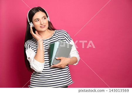 Young woman listening to audiobook on pink background. Space for text Young woman listening to audiobook on pink background. Space for text 143013569