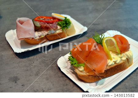 Salmon and ham chlebicek open sandwiches on plates in a prague bar for menu background and food banner promoting czech snack and beer pairing Salmon and ham chlebicek open sandwiches on plates in a prague bar for menu background and food banner promoting czech snack and beer pairing 143013582