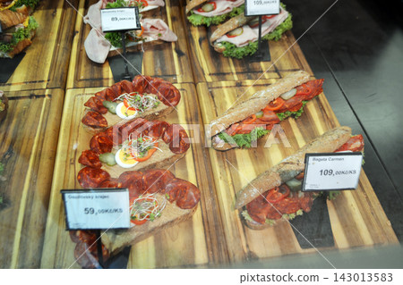 Assorted chlebicek open faced sandwiches display in prague deli window with salami and egg for menu background and food banner design Assorted chlebicek open faced sandwiches display in prague deli window with salami and egg for menu background and food banner design 143013583