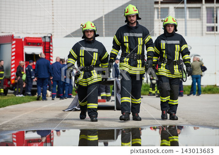 Three Firefighters Walking Toward Camera in Gear With Firetruck and Crew at Emergency Scene Three Firefighters Walking Toward Camera in Gear With Firetruck and Crew at Emergency Scene 143013683