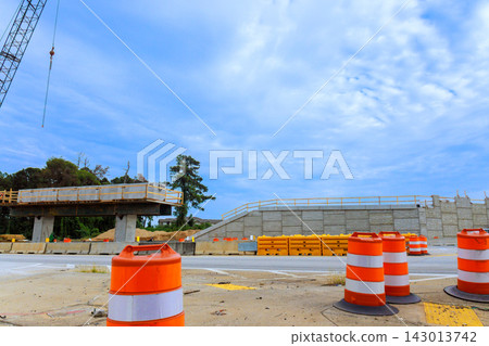 Construction is ongoing for bridge with orange safety cones at site under works busy area. Construction is ongoing for bridge with orange safety cones at site under works busy area. 143013742