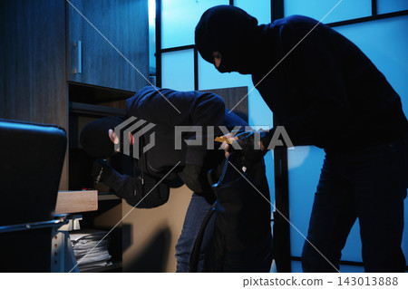 Thieves taking gold bars out of steel safe indoors at night Thieves taking gold bars out of steel safe indoors at night 143013888