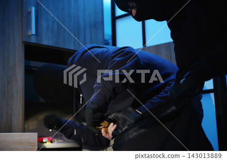 Thieves taking gold bars out of steel safe indoors at night Thieves taking gold bars out of steel safe indoors at night 143013889