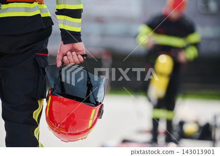 Firefighter Holding Red Helmet With Protective Gear On Emergency Scene Ready For Action Firefighter Holding Red Helmet With Protective Gear On Emergency Scene Ready For Action 143013901